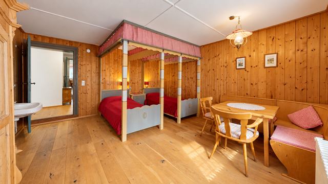 Zweibettzimmer im Dachgeschoss mit zwei Himmelbetten und Sitzecke